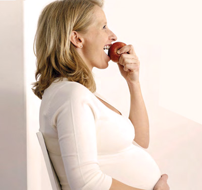 pregant woman eating apple